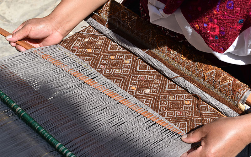 Fidencia Pérez Hernández webt ein Motiv, das das Universum symbolisiert, auf dem mit Flechten gefärbten Webstuhl (Foto © Carlos Barrera Reyes)