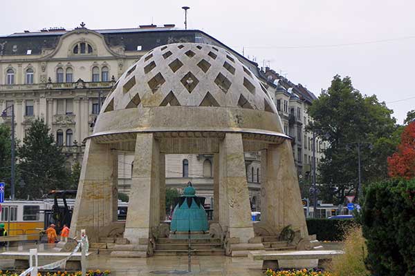 Der Hinweis auf die Quelle vor dem Gellért Bad sieht aus wie ein Helm der Arpaden